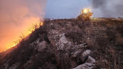 A Texas A&M Forest Service bulldozer building a containment line battles the Windy Deuce Fire in Moore County, Texas. AFP