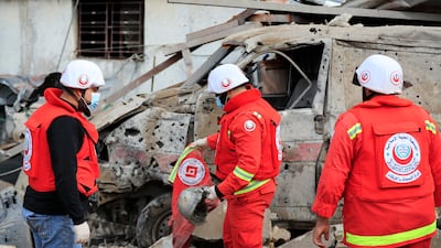 Paramedics collect equipment from the wreckage of a vehicle after the strikes. AP