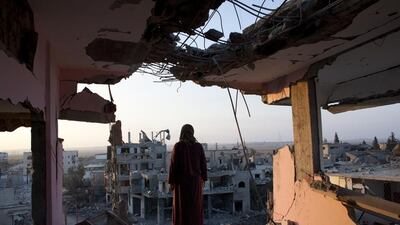 Hidya Atash stands on the top floor of his home as he overlooks the destruction in Gaza in August 2014. (Photo by Heidi Levine for The National).