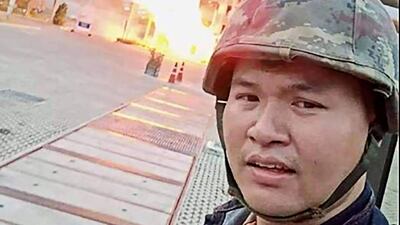 This screenshot made from the Facebook livestream video of Thai soldier Jakrapanth Thomma shows him standing in front of a building on fire during an attack in the northeastern city of Nakhon Ratchasima. AFP