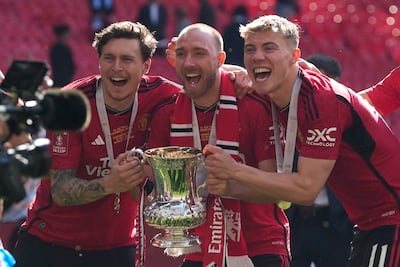 Manchester United players, Christian Eriksen, centre, Victor Lindelof, left, and Rasmus Hojlund celebrate with the trophy after winning the 2024 FA Cup. AP