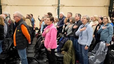 People recite the pledge of allegiance at Horizon Events Centre in Clive, Iowa. AP