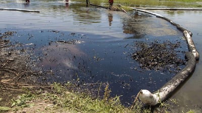 Mexican state-owned petroleum company Pemex’s workers clean the San Juan river after an oil spill caused by a clandestine taking in a pipeline in San Juan Cadereyta, Nuevo Leon state, Mexico, on August 23, 2014. Julio Cesar Aguilar / AFP