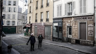 People walk their dog on a deserted street transformed into a movie set, in Paris, France. The shooting of a cinema film taking place in the 1940s in the Montmartre district was interrupted and its sets left in place as France is under lockdown. EPA