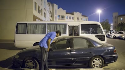 Arif Sibte, a resident, inspects an abandoned car in the English Cluster of International City in Dubai. Antonie Robertson / The National