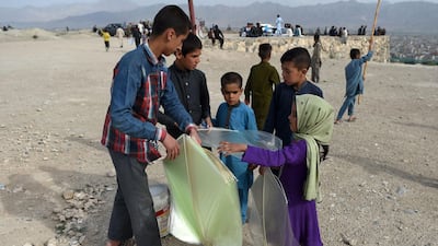 A young kite vendor, right, sells plastic kites to children.