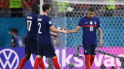 Mbappe is consoled by teammates after missing the penalty. AFP