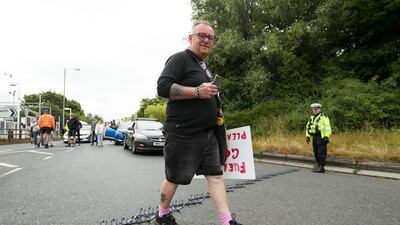 A protester walks over a single tyre deflation device, known as a stinger, as police close off the junction at Ferrybridge services in Leeds. Getty