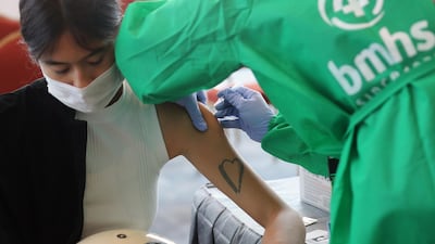 A woman receives a dose of AstraZeneca vaccine during a Covid-19 vaccination drive at a shopping mall in Jakarta, Indonesia. EPA