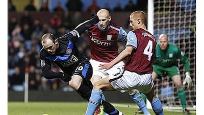 Manchester United's Wayne Rooney, left, tries to beat Aston Villa's Steve Sidwell, right, and James Collins when the two teams drew 1-1 earlier this month.