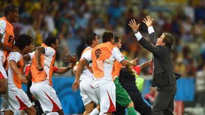 Costa Rica players celebrate with Jorge Luis Pinto after their third goal in the 3-1 win against Uruguay at the 2014 World Cup. Getty