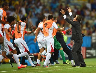 Costa Rica players celebrate with Jorge Luis Pinto after their third goal against Uruguay in the 2014 World Cup group match. Getty