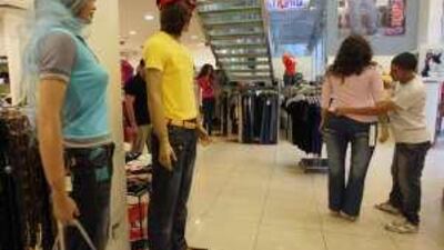 An employee dresses a large mannequin at the clothing store Strong in Amman, where overweight shoppers can find fuller sizes.