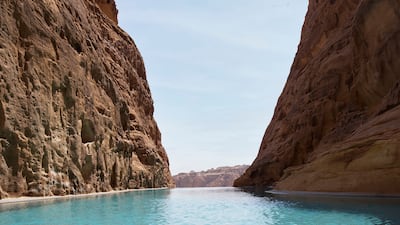 The rock pool is framed by two majestic mountains.