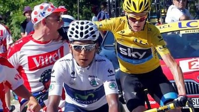 Yellow jersey holder Chris Froome pushes a spectator out of the way as he cycles behind Nairo Quintana, who won the 20th stage. Froome is now a simple ride into Paris away from winning the Tour de France.