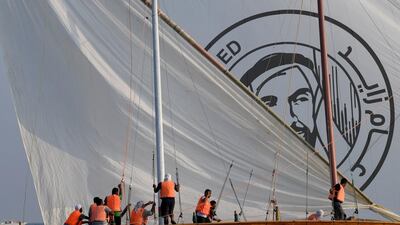 Emirati sailors hoist their sail bearing the logo of UAE Founding Father Sheikh Zayed.