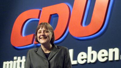 Angela Merkel poses under a CDU logo at the end a CDU party convention in Essen, April 11, 2000. Reuters