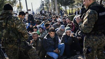 Macedonian police officers stand guard as migrants from Liberia, Morocco, Pakistan, Sri Lanka and Sudan block railway tracks near Gevgelija on the Greek-Macedonian border on November 19, 2015. Macedonia, Slovenia, Serbia and Croatia closed their borders on Friday to those not coming from war-torn countries. Dimitar Dilkoff/AFP Photo