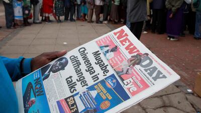 A man reads a newspaper as residents queue to draw money at a bank in Harare, Zimbabwe, November 17, 2017. REUTERS/Philimon Bulawayo