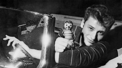 (FILES) This file photo taken in the 1960s shows French singer Johnny Hallyday posing his a car. France's best-known rock star Johnny Hallyday has died aged 74 after a battle with lung cancer, his wife Laeticia told AFP on December 6, 2017. / AFP PHOTO / -