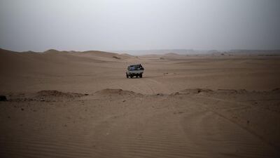 A vehicle transporting a group of African migrants drives through the desert on their journey from Ghat.