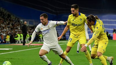 (From L) Real Madrid's Belgian forward Eden Hazard fights for the ball with Cadiz's Spanish forward Ruben Sobrino and Cadiz's Uruguayan defender Pacha Espino during the Spanish league football match between Real Madrid CF and Cadiz CF, at the Santiago Bernabeu stadium in Madrid on December 19, 2021. (Photo by JAVIER SORIANO / AFP)