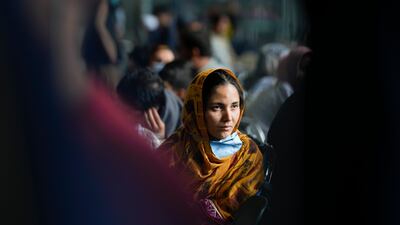 A woman from Afghanistan waits with other evacuees to fly to the US or another safe location inside a hanger at the US Air Base in Ramstein, Germany. AP Photo