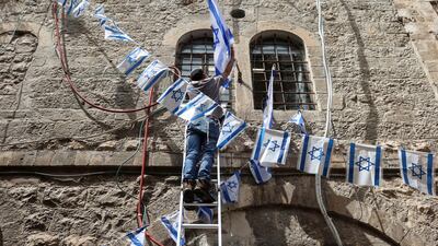A man hangs Israeli flags in Jerusalem's Old City. Reuters