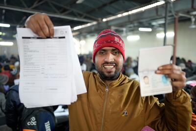 Anup Singh holds up his passport and application form for a job in Israel, at a recruitment event in Lucknow, northern India. AP