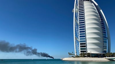 Smoke billows from a vessel on fire off the coast of Dubai. Farah Andrews / The National