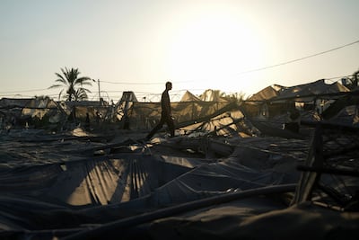 Palestinians look at the destruction caused by overnight Israeli strikes on a crowded encampment in Al Mawasi on Tuesday. AP
