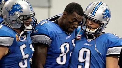 Detroit Lions centre Dominic Raiola, left, and quarterback Matthew Stafford, right, help Calvin Johnson off the field after the wide receiver's touchdown catch late in the second half that helped Detroit overcome Dallas.