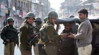 Indian policemen question a man at a makeshift checkpoint in Srinagar where undeclared curfew restrictions were imposed yesterday.