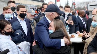 Mr Biden, flanked by the mayor of Warsaw Rafal Trzaskowski and Polish Prime Minister Mateusz Morawiecki, hugs a woman as he visits Ukrainian refugees. Reuters