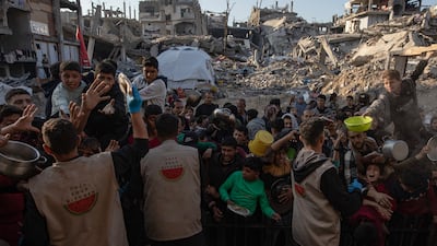 Internally displaced Palestinians jostle for food handouts from a charity kitchen, in Beit Lahia, northern Gaza. EPA