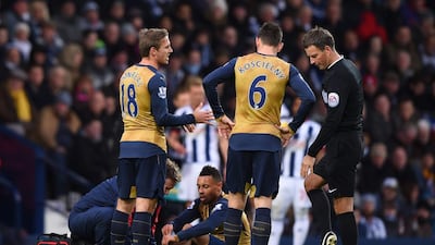 Arsenal's Francis Coquelin, centre, receives medical treatment in the match against West Bromwich Albion and was later ruled out until end of 2015. Shaun Botterill/Getty Images