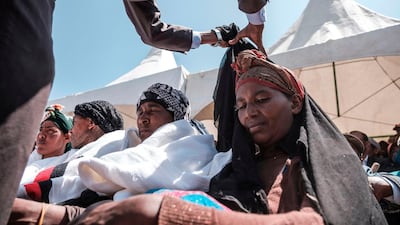 A man pulls out a mourning cloth from a woman during a memorial ceremony at the crash site of the Ethiopian Airlines Flight 302 airplane accident in Tulu Fara, Ethiopia. AFP