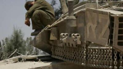 An Israeli soldier rests on a tank near the Sufa Crossing between southern Israel and the Gaza Strip. Israel and the Hamas rulers of Gaza say four crossings reopened on schedule on July 2, 2008.