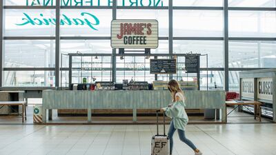 A traveller walks past the check-in desks at London Gatwick Airport. Concerns about catching the virus continue to affect decisions on travelling. Bloomberg
