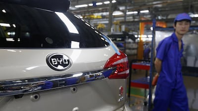 A worker passes by a car being manufactured at a BYD assembly line in Shenzhen, China. Bobby Yip/ Reuters