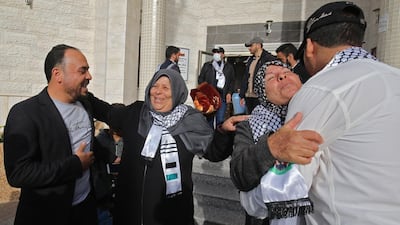 Palestinians welcome relatives leaving the Muscat Medical Center in Khan Yunis after 21 days in quarantine since their arrival to one of the entry crossings to the besieged Gaza Strip, returning from a trip abroad. AFP