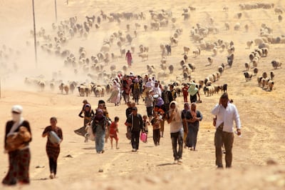 Displaced Yazidis, fleeing violence from forces loyal to ISIS in Sinjar town, walk towards the Syrian border, on the outskirts of Sinjar mountain, near the Syrian border town of Elierbeh, in August 2014. Reuters