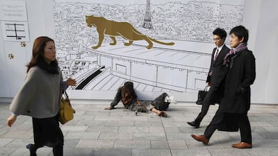 A man takes a nap along a street next to his belongings as pedestrians walk past at Tokyo's Ginza shopping district. Gross domestic product shrank by an annualised 1.6 per cent in July-September, after plunging 7.3 per cent in the second quarter following a rise in the national sales tax, which clobbered consumer spending.Yuya Shino / Reuters