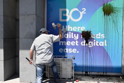 A man strikes a bank building with a hammer during the demonstration in Beirut. EPA