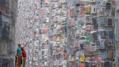 Visitors look at the Parthenon of Books created by the Argentinian artist Marta Minujin in Kassel, Central Germany. Boris Roessler / dpa / AFP Photo