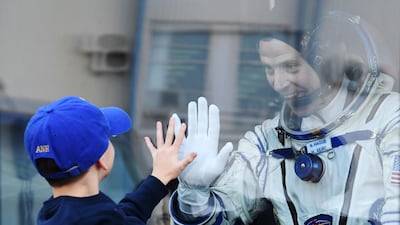 Nick Hague goes hand to hand with a child prior to the launch. EPA
