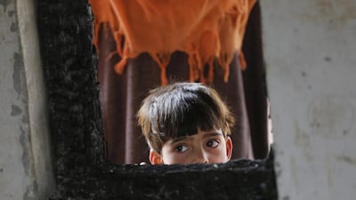 A Kashmiri Muslim child looks from a window of a torched school building on the outskirts of Srinagar in Indian Kashmir. According to sources there, 27 schools have been burnt during three months of summer unrest across Kashmir and authorities on November 2 shut down more than 300 schools. Farooq Khan / EPA