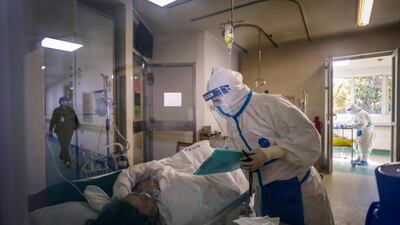 A medical worker checks on a patient's condition at Jinyintan Hospital designated for new coronavirus infected patients, in Wuhan in central China's Hubei province. AP