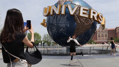 A tourist in front of a sign of the Universal Resort, at the Universal Studios theme park, as it reopens to the general public. Reuters