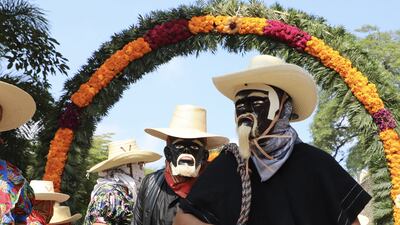 Men wearing masks dance during the offering in memory of their relatives amid Day of the Dead. EPA